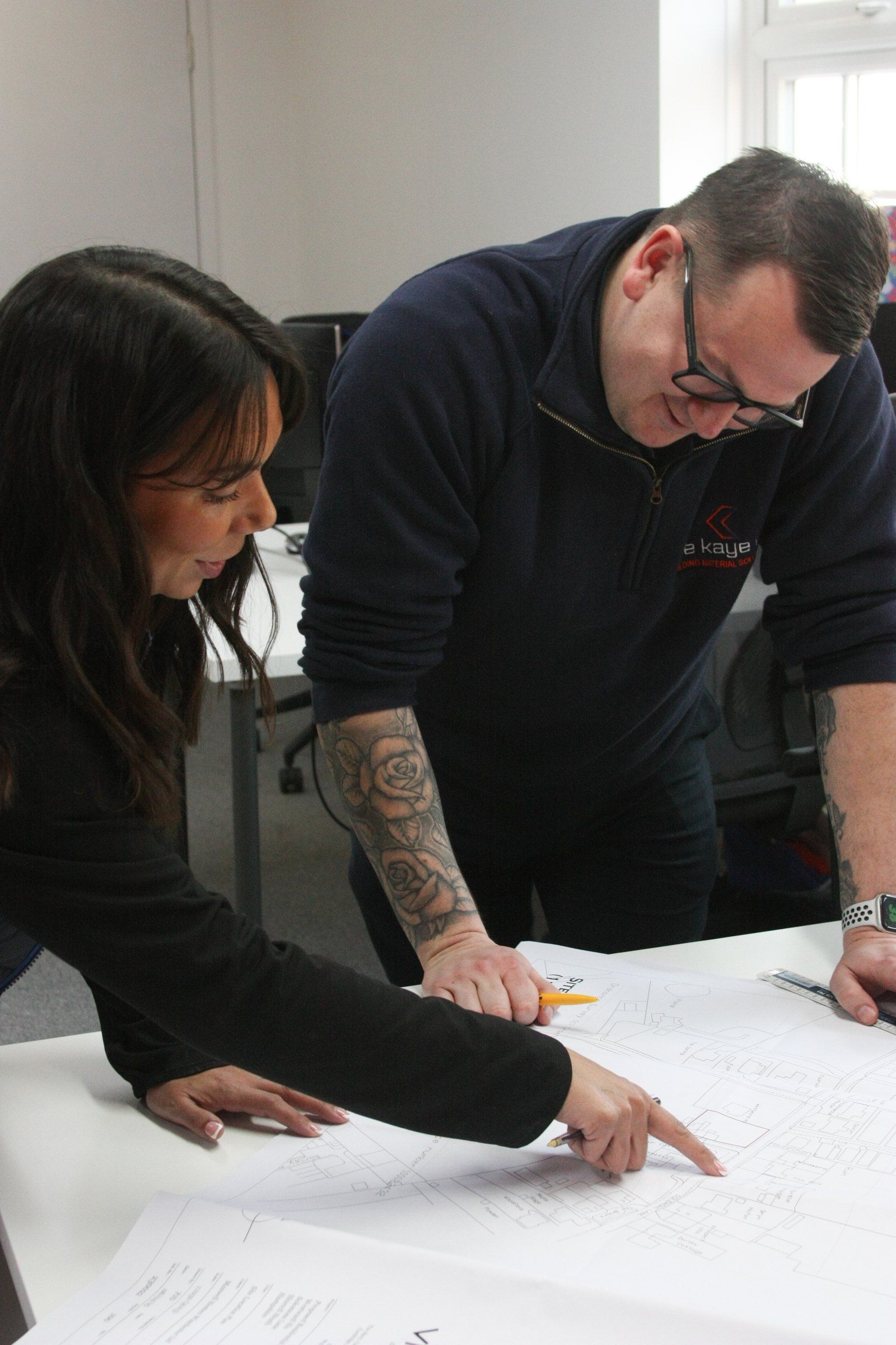 Two of the team checking a drawing for a materials list